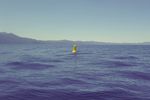 A bright yellow buoy in the center, surrounded by still waters
